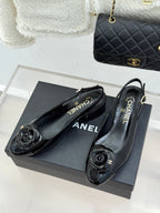 Black patent leather slingback flats with flower-like CC medallions and CHANEL logo