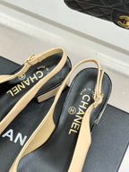 Women’s Chanel slingback heels close-up, cream straps with black logo lining