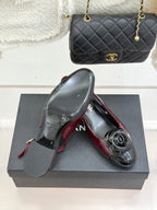 Burgundy patent slingback flats with black CC toe emblem, pair on box