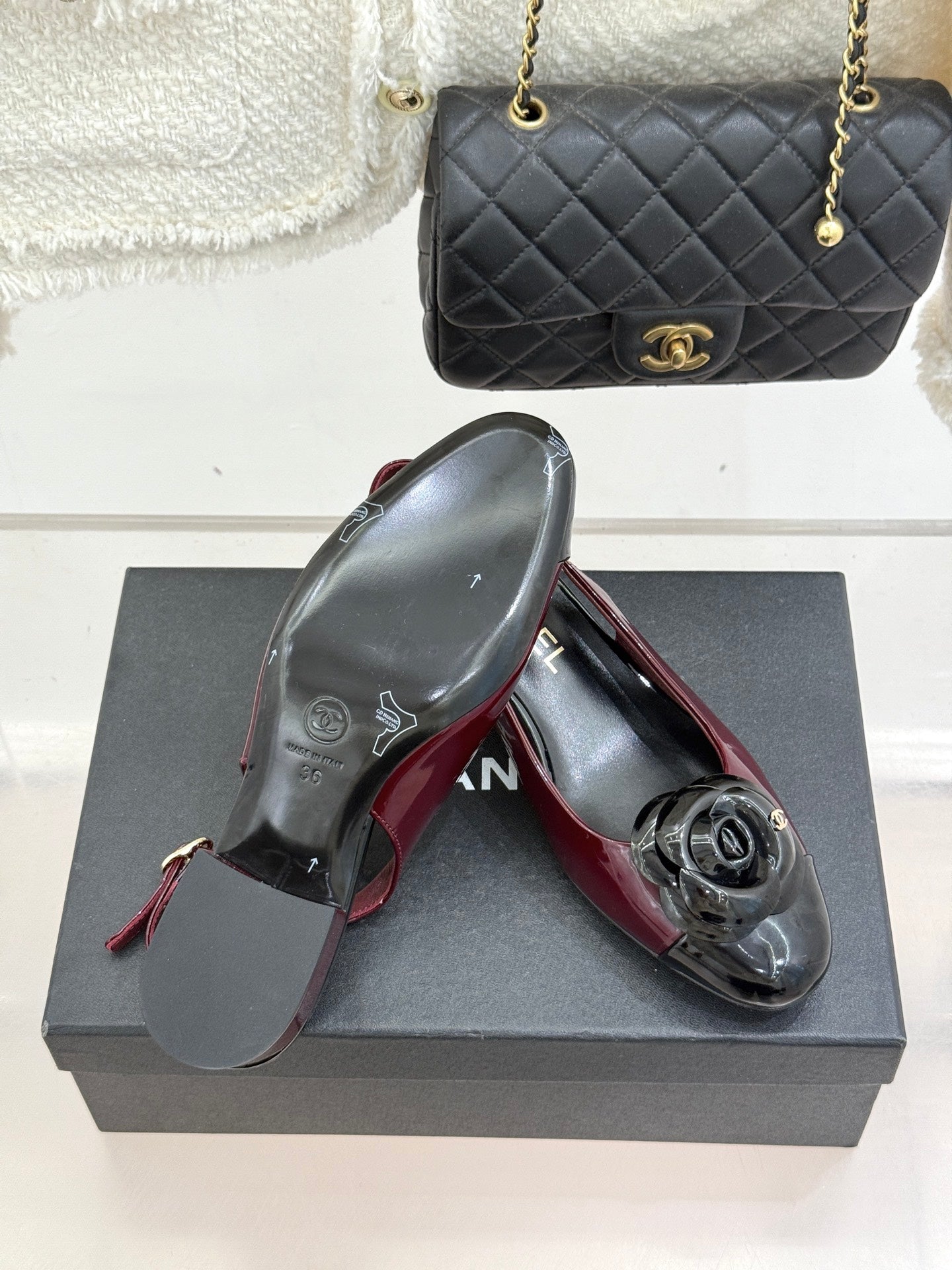 Burgundy patent slingback flats with black CC toe emblem, pair on box