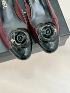 Burgundy patent flats with round black CC toe hardware, front view