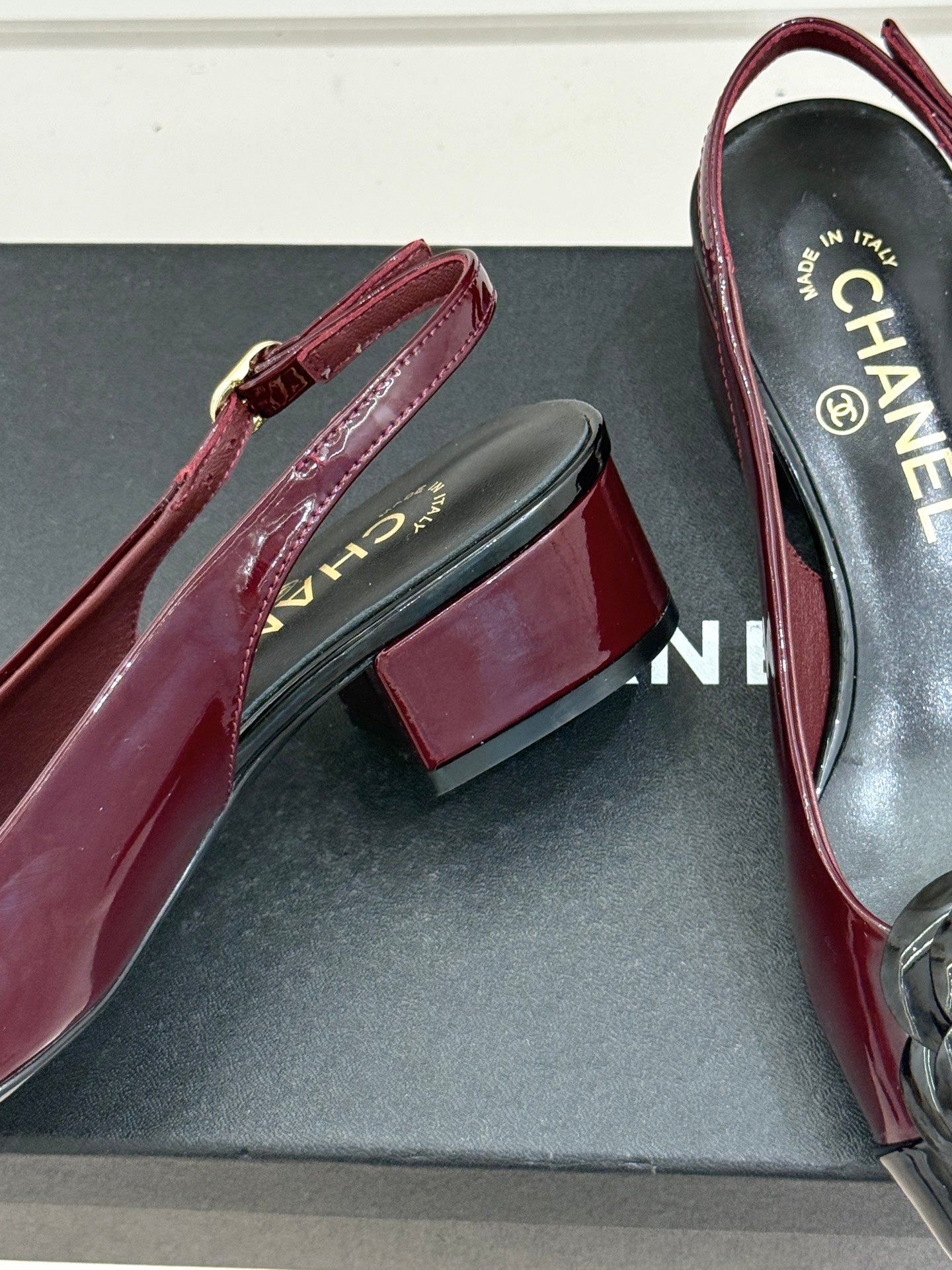 Burgundy patent slingback flats with black accent strap and CC toe emblem