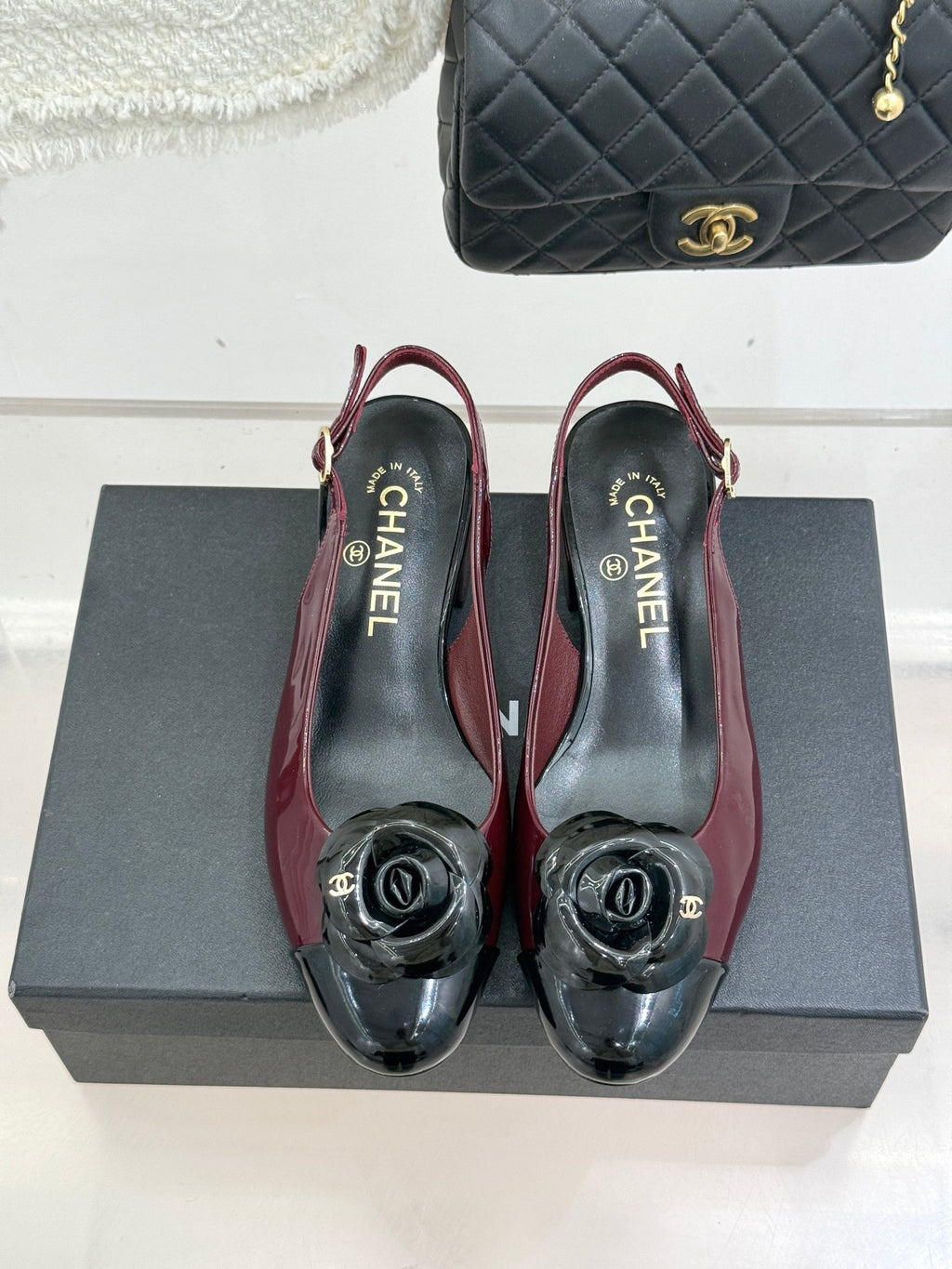 Burgundy slingback flats with black toe CC emblem; close-up pair