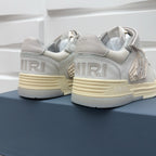 Amiri sneakers heel view in light gray with “AMRI” branding on side and sole
