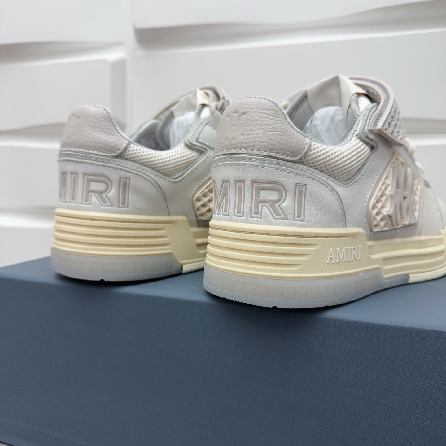 Amiri sneakers heel view in light gray with “AMRI” branding on side and sole