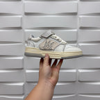 Amiri low-top sneaker held up in white with studded side strap and lace-up