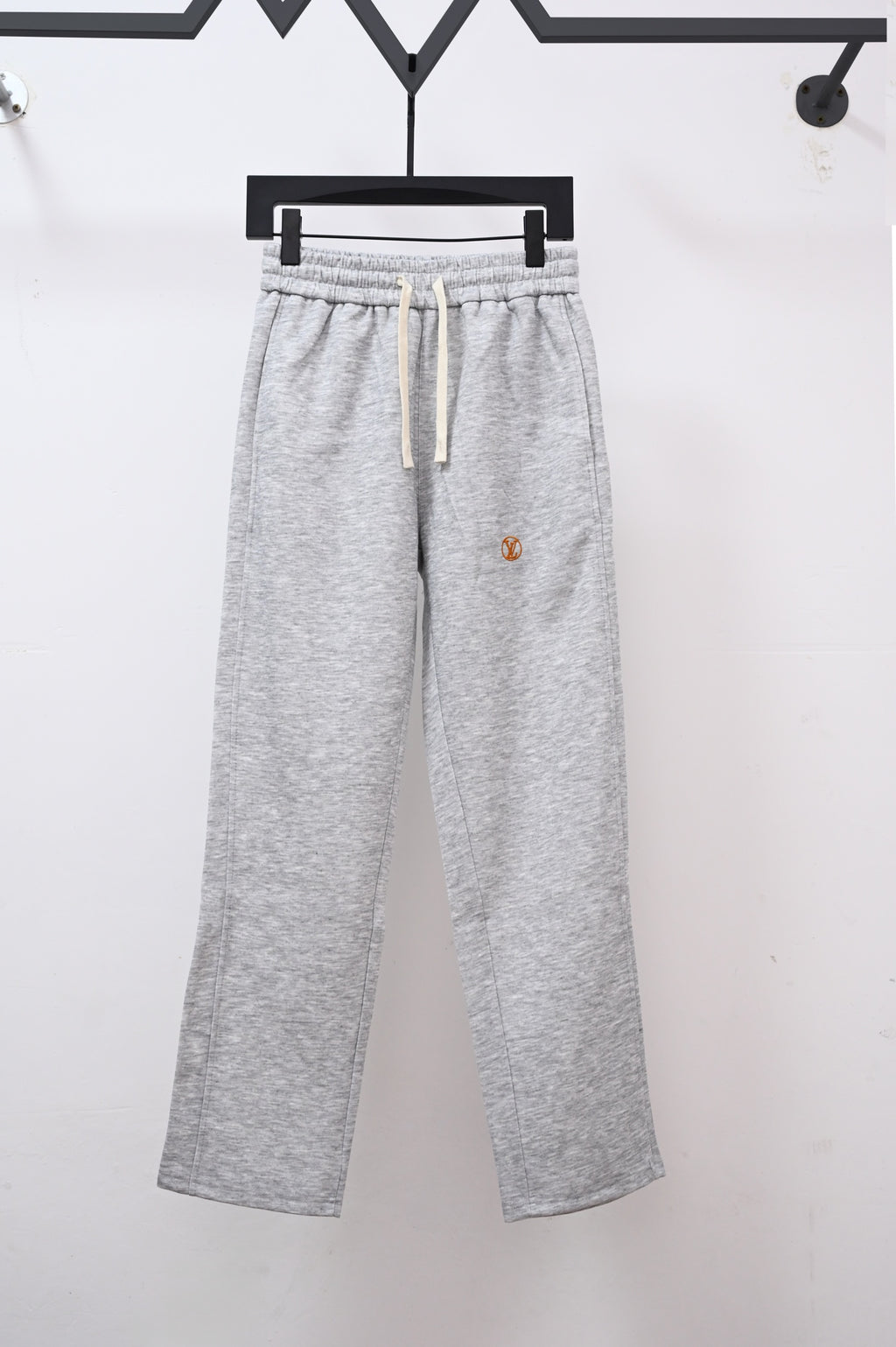 Heather gray sweatpants with drawstring and small Louis Vuitton emblem on leg
