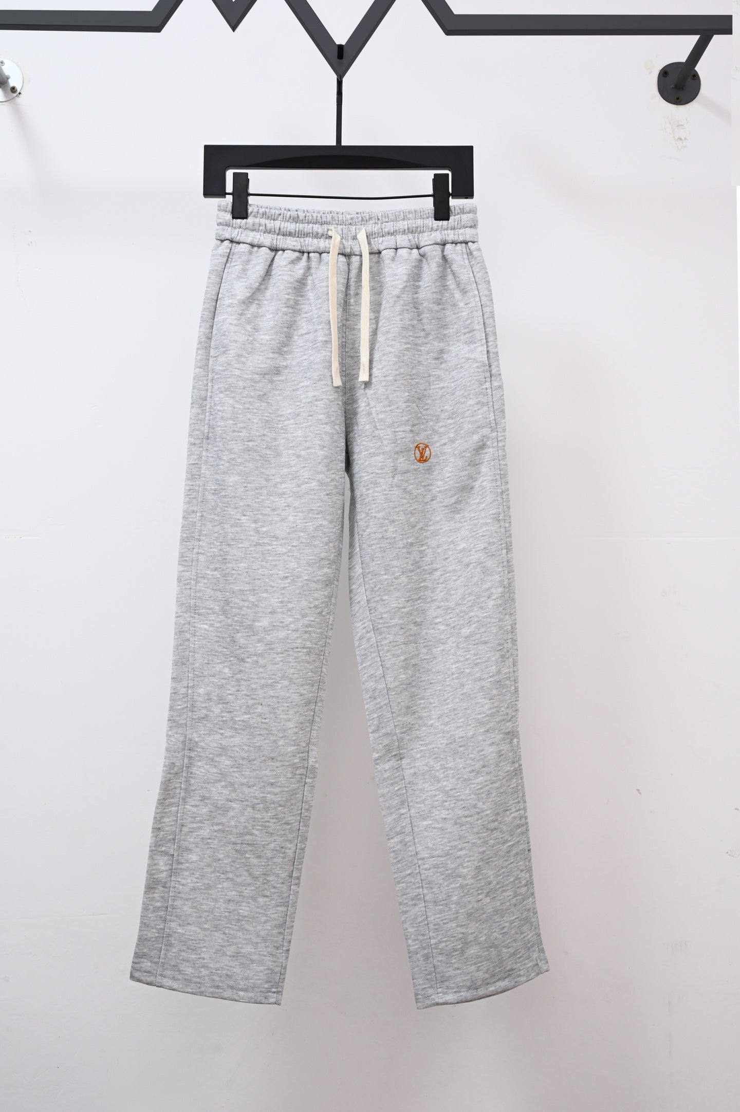 Heather gray sweatpants with drawstring and small Louis Vuitton emblem on leg