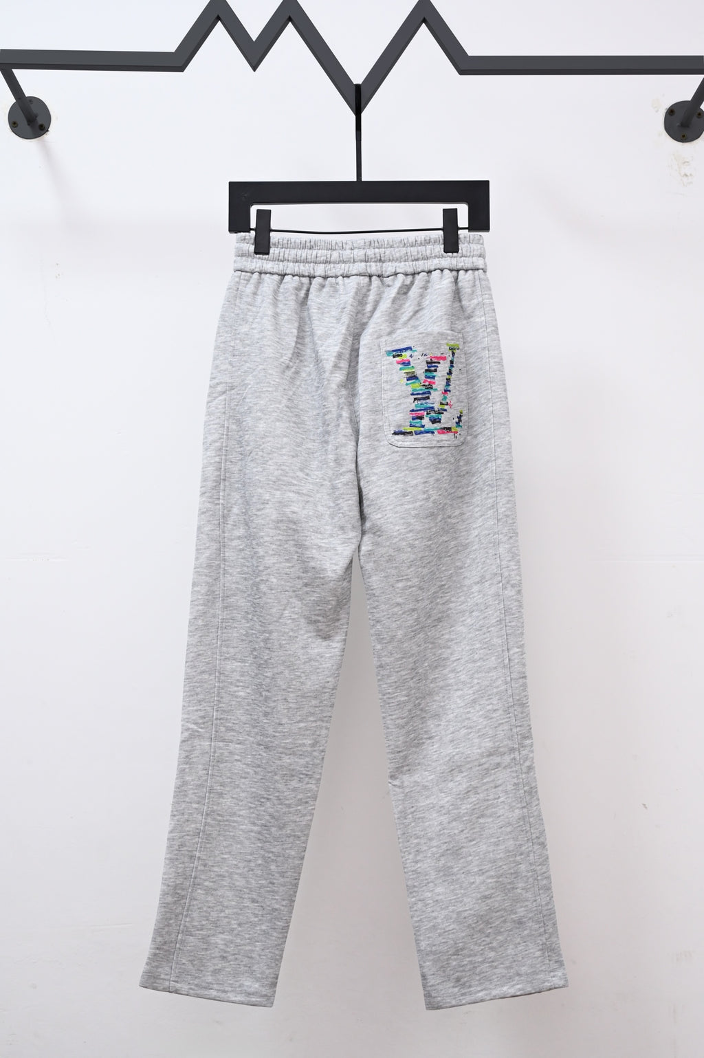 Gray sweatpants with drawstring, elastic waist, and colorful LV logo patch