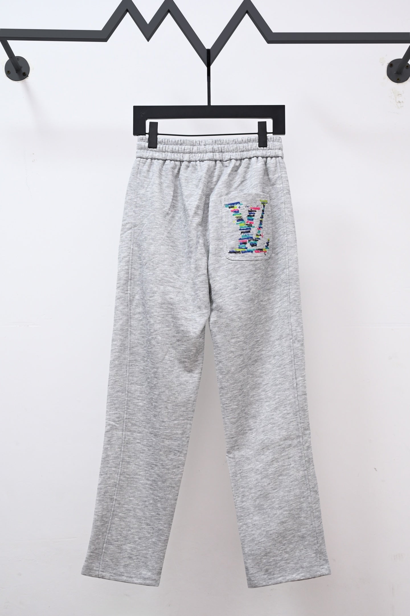 Gray sweatpants with drawstring, elastic waist, and colorful LV logo patch