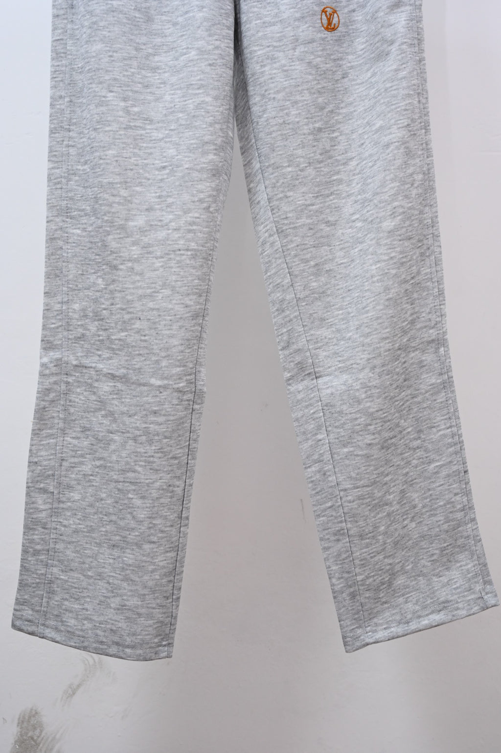Gray sweatpants legs with small Louis Vuitton emblem