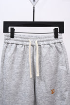 Gray drawstring sweatpants with elastic waistband, front view close-up