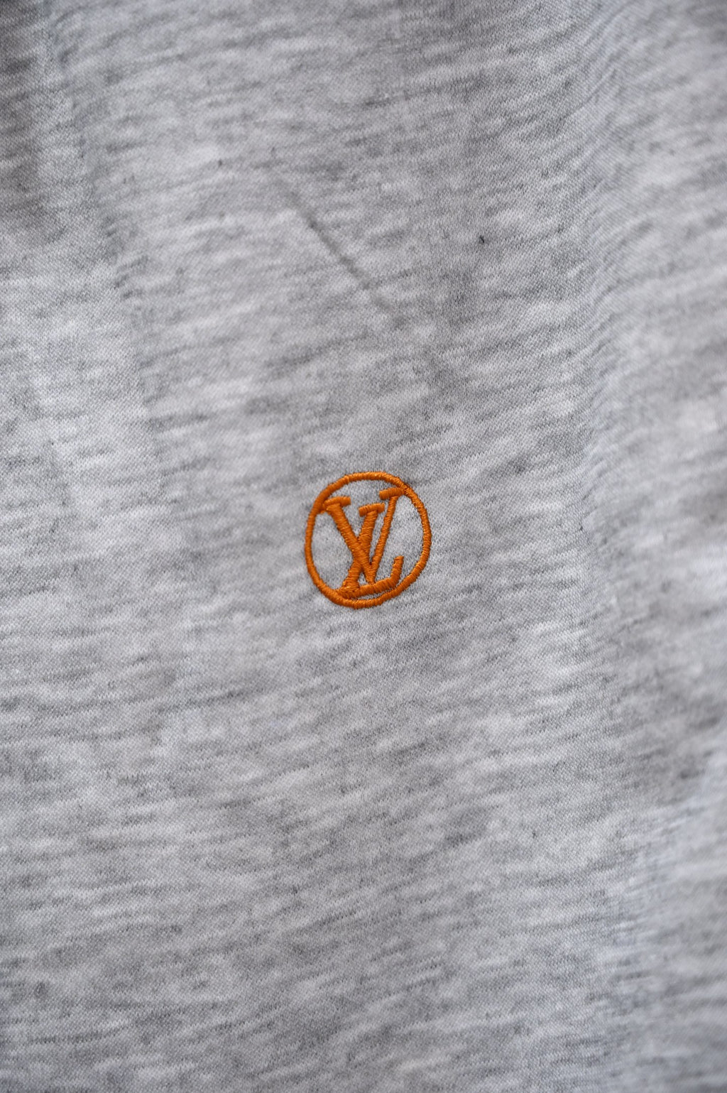Gray sweatpants with small orange Louis Vuitton emblem