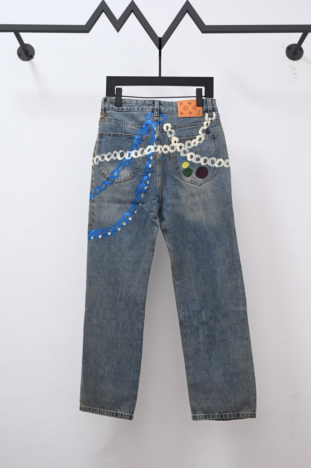 Denim pants with multicolor chain trim and patchwork graphics across the front