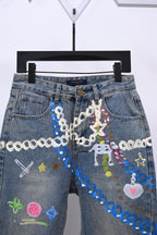 Denim pants with dense multicolor applique and chain detail on front