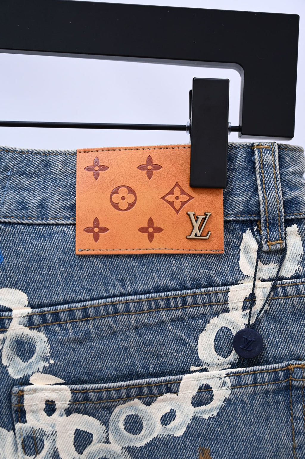 Denim pants waistband detail with Louis Vuitton leather patch and printed charm motifs