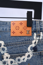 Denim pants waistband detail with Louis Vuitton leather patch and printed charm motifs