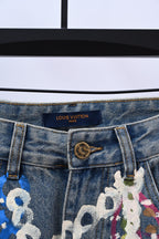 Denim pants detail with Louis Vuitton label and decorative chain and charm print