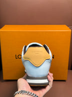 White Louis Vuitton low-top sneaker from back with brown heel trim and yellow collar accent