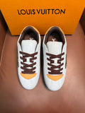 Pair of white Louis Vuitton low-top sneakers with brown laces and yellow curved accents