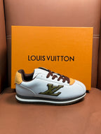 White Louis Vuitton low-top sneaker with brown laces, yellow accent patch, and green logo detail