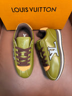 Green low-top sneakers with dark brown laces, LV logo, and white midsole