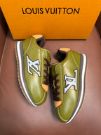 Green leather sneakers with contrasting laces and blue LV logo on the sides