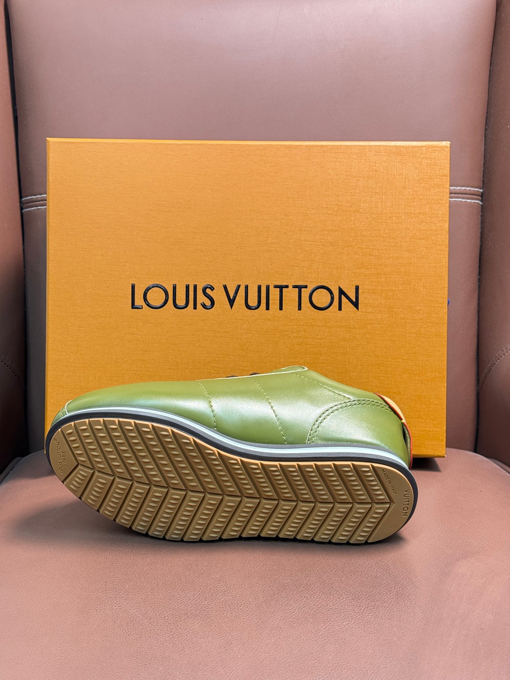 Green sneaker outsole view with textured tread and yellow-edged midsole