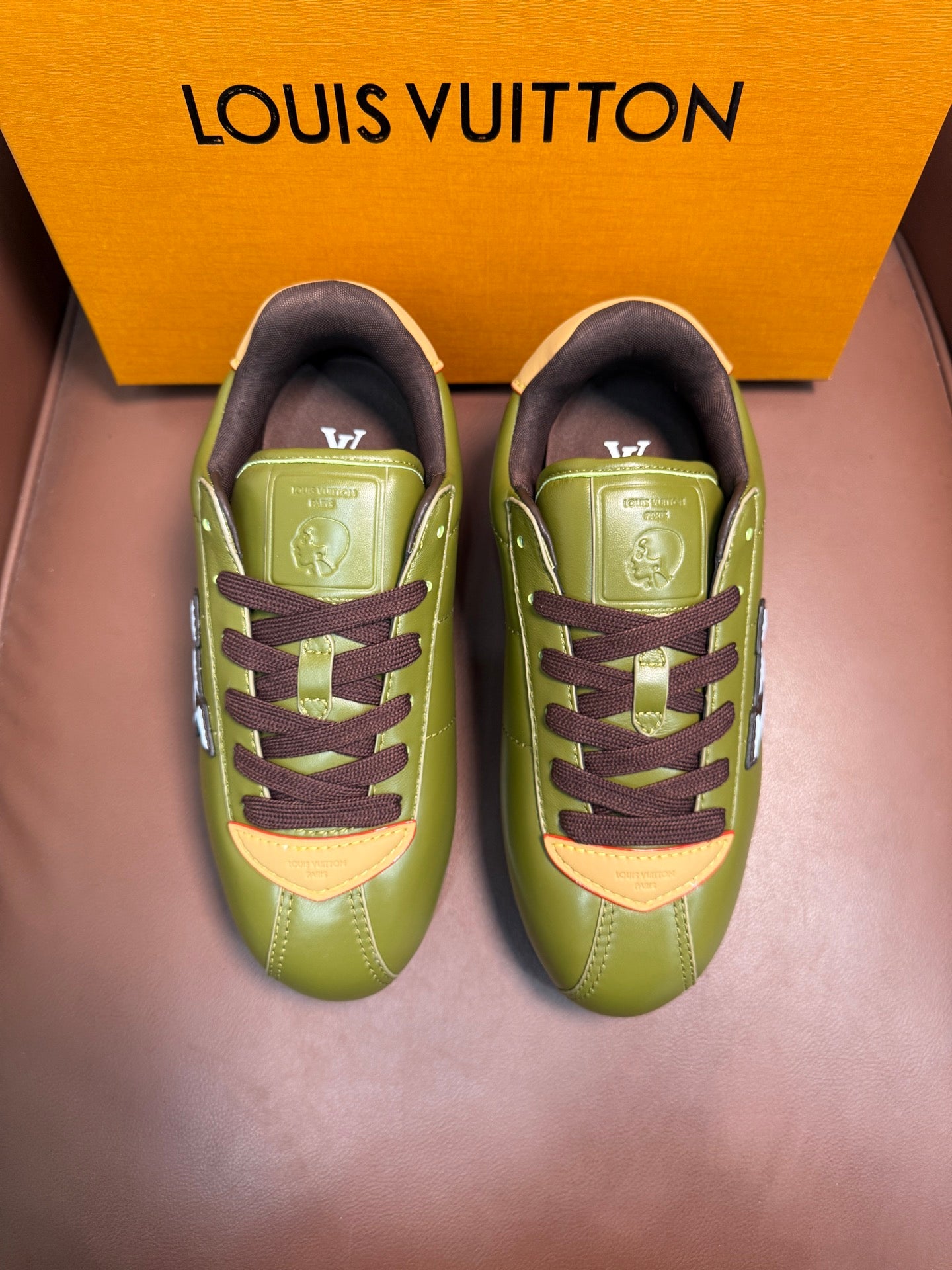 Green lace-up sneakers with dark brown laces and side LV emblem