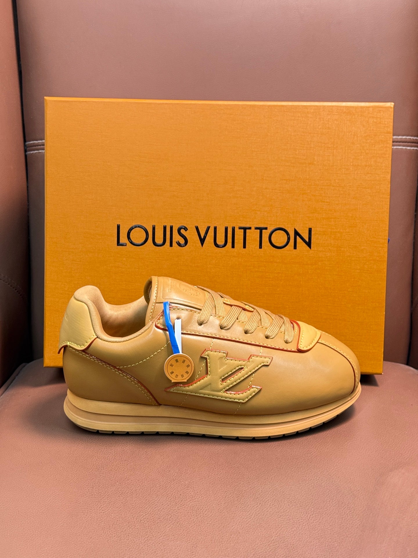 Louis Vuitton luxury sneakers in light tan with lace-up front and logo patch