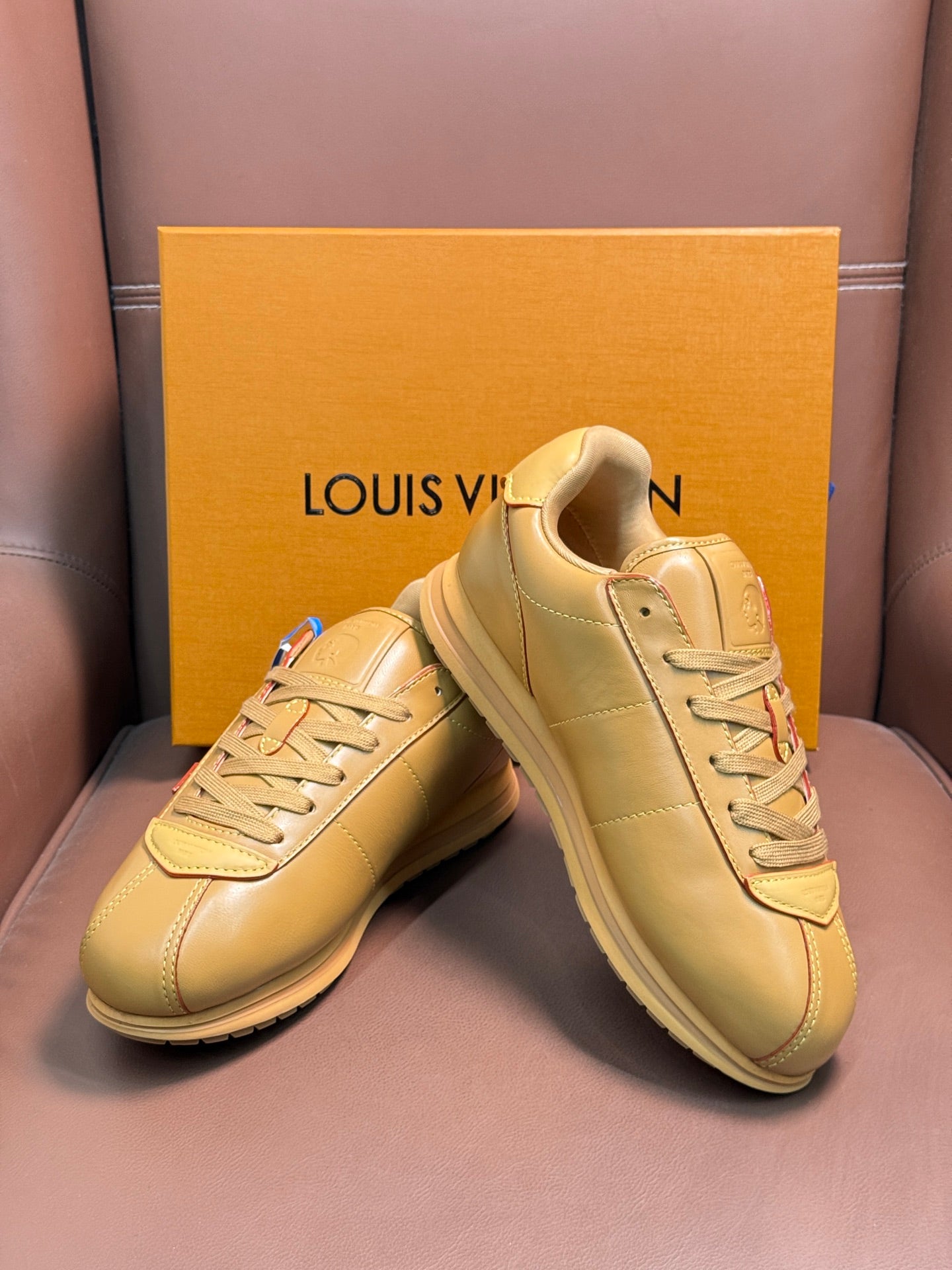 Louis Vuitton luxury sneakers in light tan, angled front and side