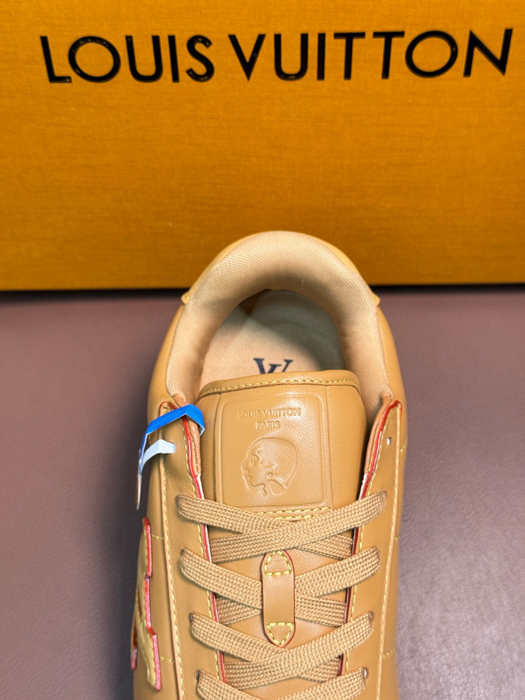Louis Vuitton luxury sneakers in light tan, close-up of tongue and lace area