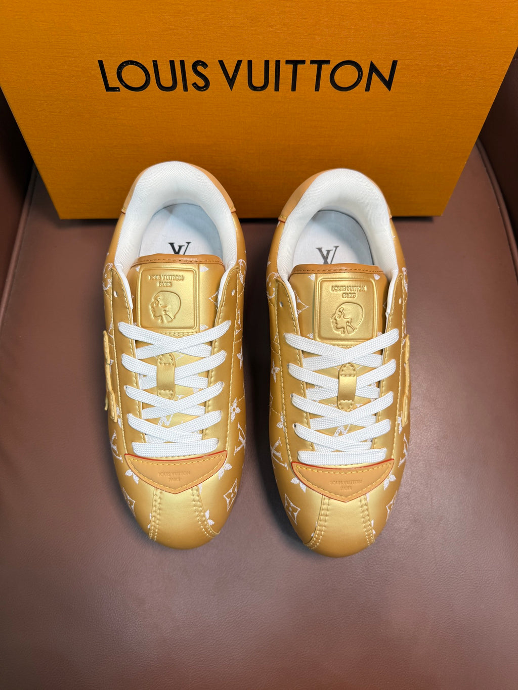 Louis Vuitton gold monogram sneakers with white laces and blue-trim sole, front view