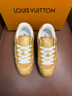 Louis Vuitton gold monogram sneakers with white laces and blue-trim sole, front view