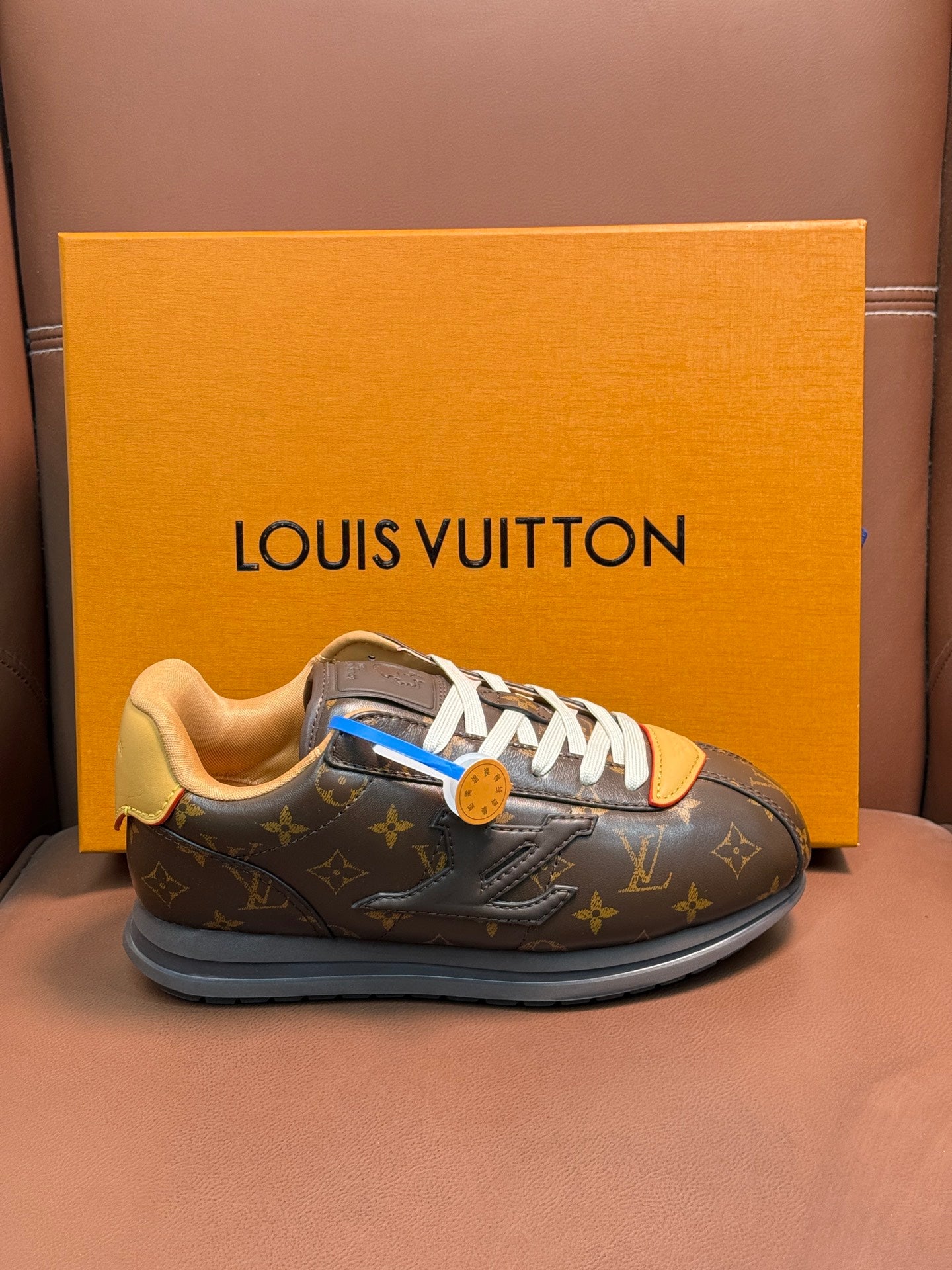 Louis Vuitton monogram sneakers with white laces, tan lining, and blue trim detail