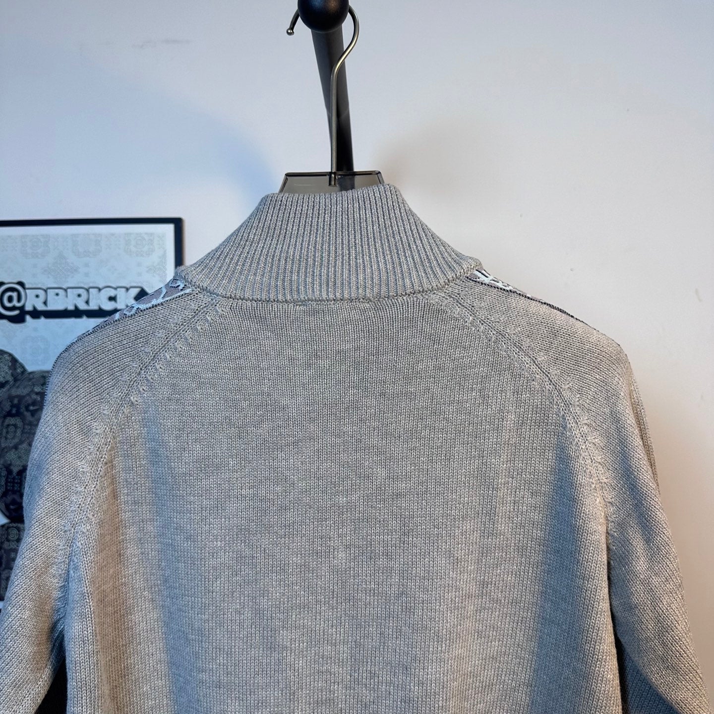 Light blue knit zip-up sweater with ribbed turtleneck collar on a mannequin