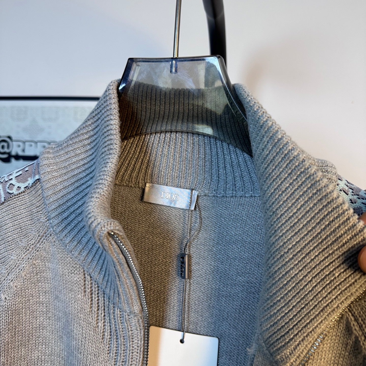 Light blue knit zip-up sweater lining and inner label visible through collar opening