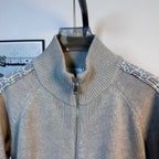 Light blue knit zip-up sweater with ribbed stand collar and patterned side trim