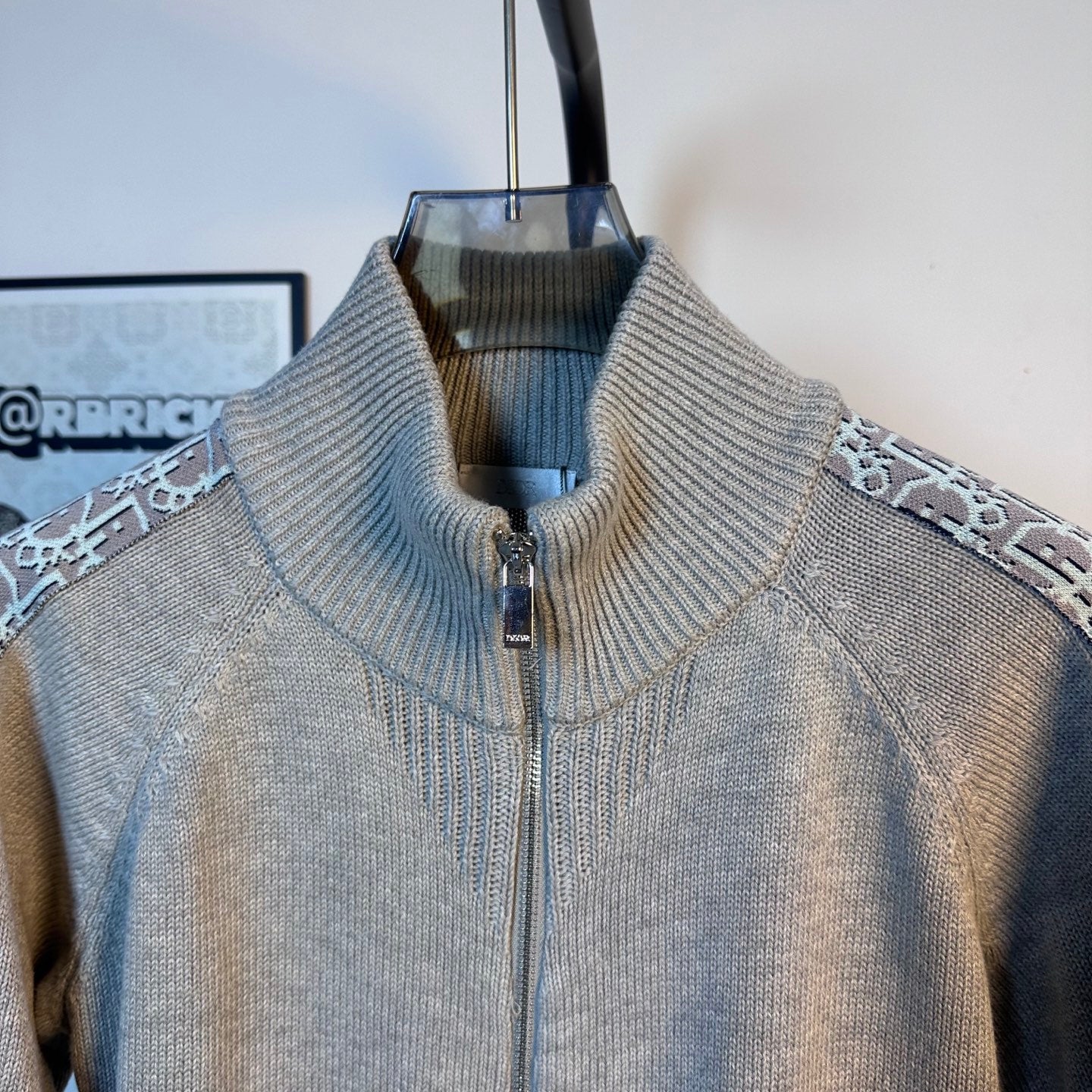 Light blue knit zip-up sweater with ribbed stand collar and patterned side trim