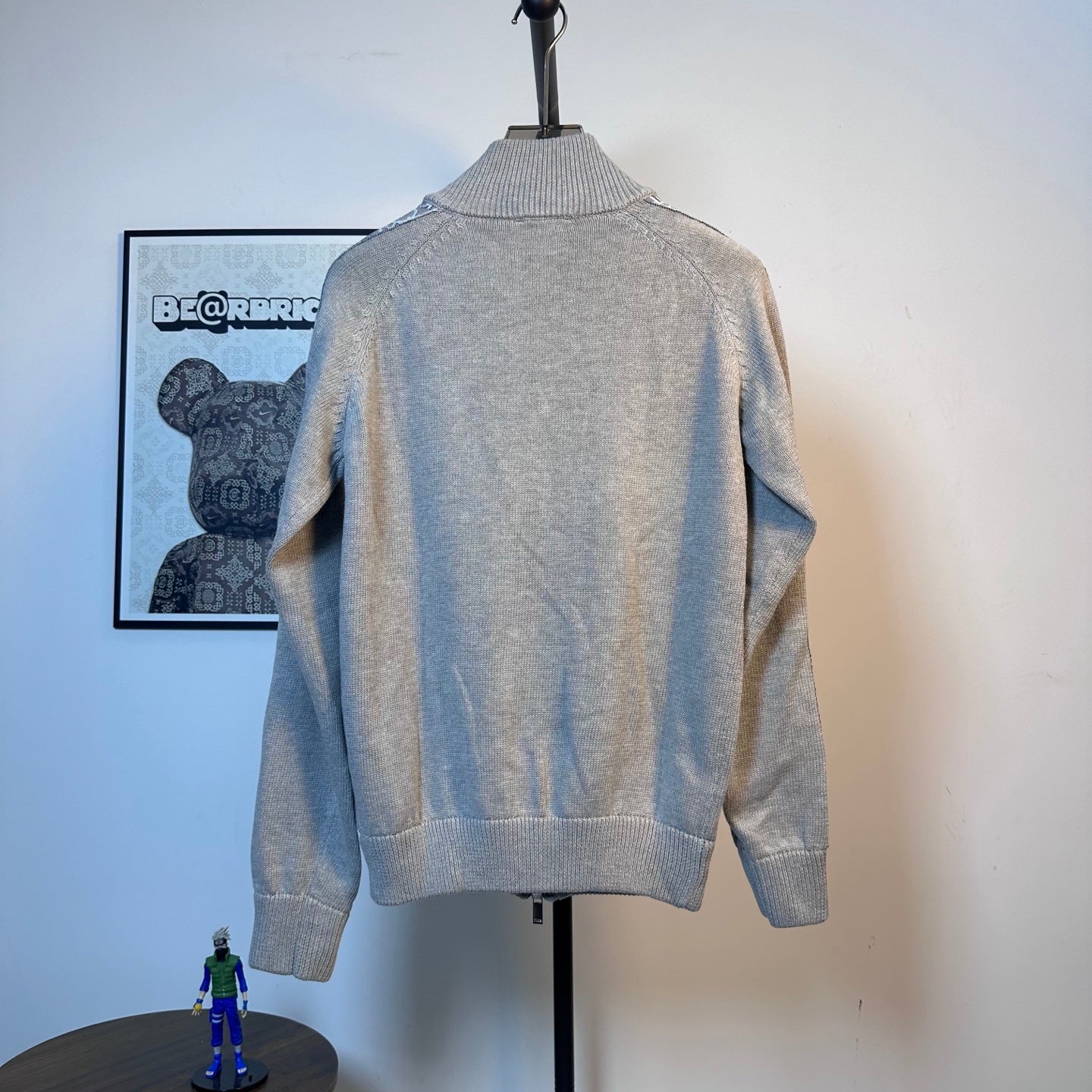 Light blue knit zip-up sweater, back view, ribbed hem and neckline details