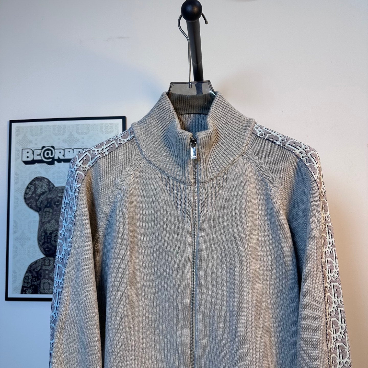 Light blue knit zip-up sweater with stand collar and front zipper on a mannequin