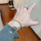 Gucci silver bangle bracelet on wrist, engraved cuff detail