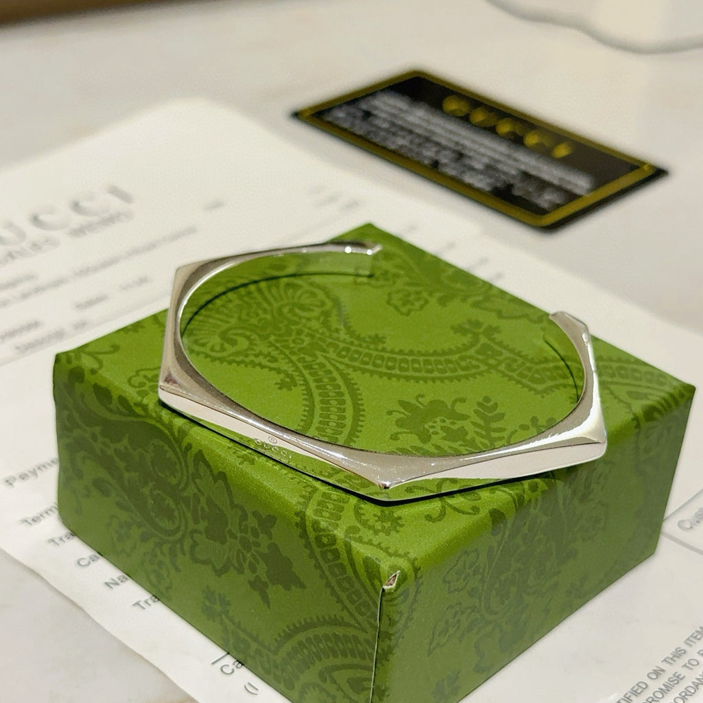 Gucci silver bangle bracelet on green box, front view