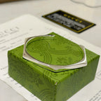 Gucci silver bangle bracelet on green box, front view