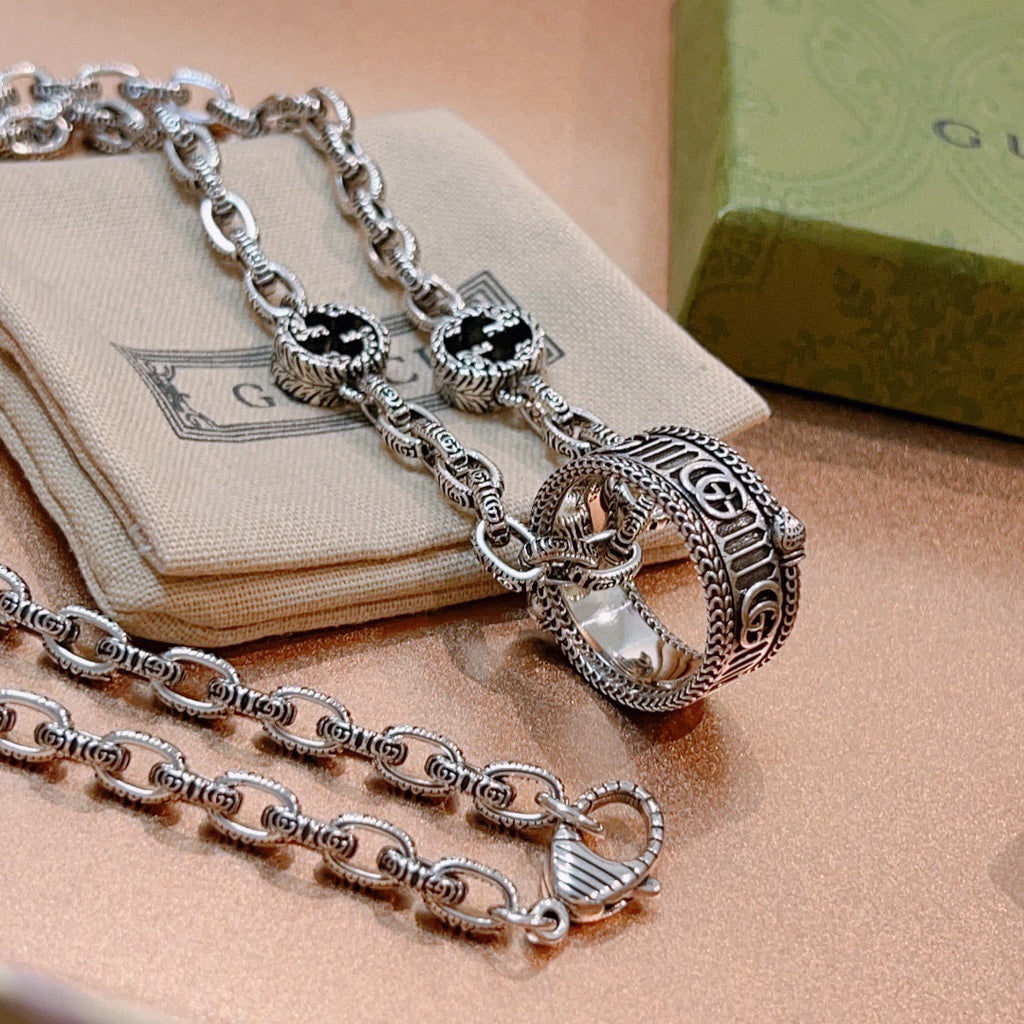Silver-tone chain necklace with double oval pendant and black enamel insets