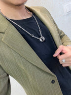 Silver-tone chain necklace with small oval logo pendant near collar