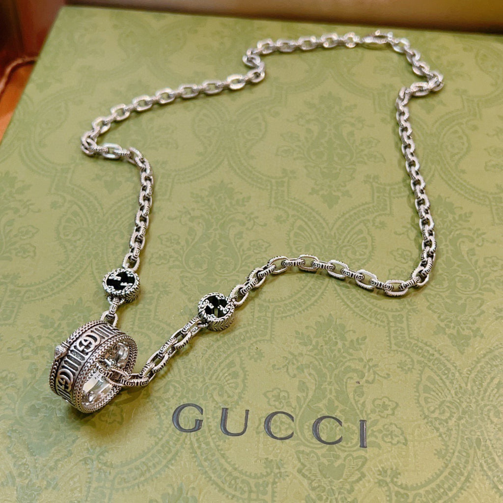Silver-tone chain necklace with large round black-and-silver medallion pendant