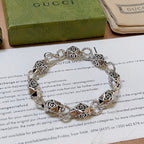 Silver logo-link bracelet with detailed charm links