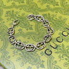 Silver-tone chunky link bracelet on surface, interlocking oval links and clasp