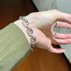 Silver-tone chunky link bracelet on hand, interlocking oval links